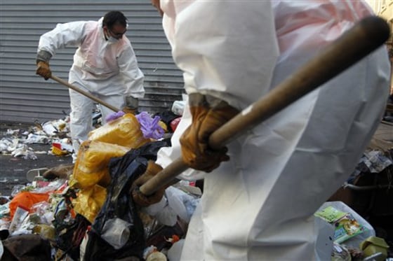 Garbage collectors begin tackling Marseille's reeking mounds of trash in the center of Marseille, southern France on Tuesday, Oct. 26, 2010. Striking garbage collectors left 9,000 tons of garbage piled up in the streets in the last two weeks.